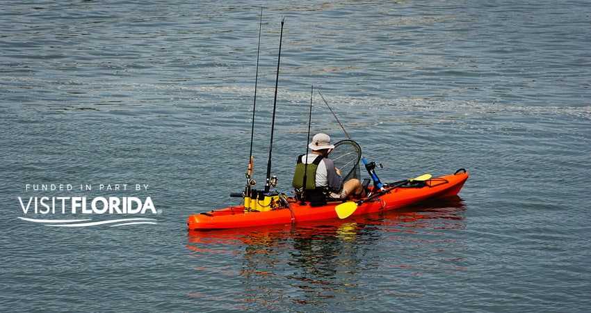 Man kayaking with visit florida logo