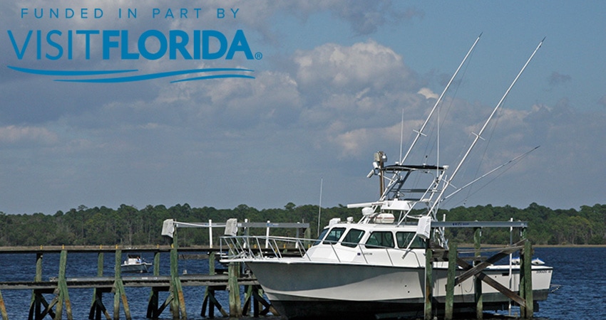 Picture of boat at dock with visit florida logo