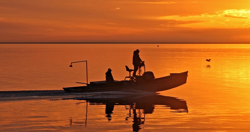 2 people on boat at sunset